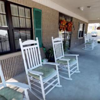 A cozy porch with white rocking chairs and decorative elements.