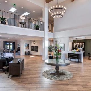 Spacious and elegantly designed lobby with a large chandelier, comfortable seating, and decorative plants.