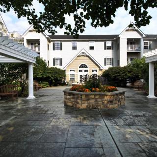 A modern building with a landscaped courtyard and stone pathway.