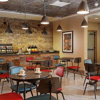 A cozy and modern cafe interior with colorful seating and rustic brick walls.