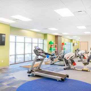 A well-lit fitness center equipped with various exercise machines.
