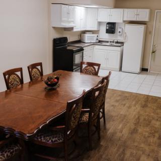 A cozy dining and kitchen area with a wooden table and modern appliances.