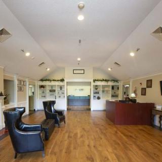 A spacious lobby area with seating and a reception desk.