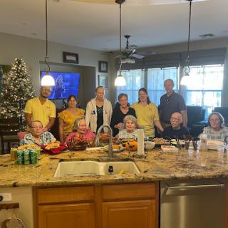 A joyful gathering of family and friends in the kitchen, celebrating together.