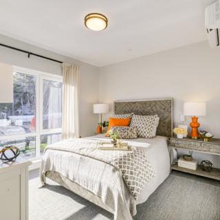 A modern and bright bedroom with stylish decor and a large window.