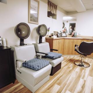 A cozy hair salon setup featuring styling chairs and hair dryers.