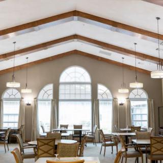 A spacious dining area with elegant pendant lighting and vaulted ceiling beams.