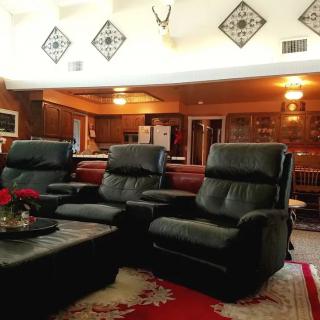A cozy living room with leather recliners and an open view into the kitchen.
