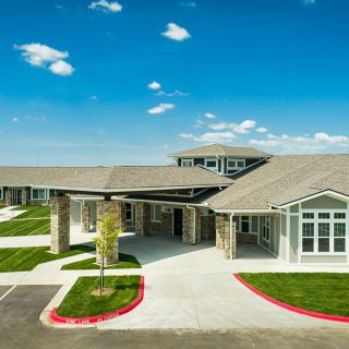 Modern building with a paved driveway and clear skies.