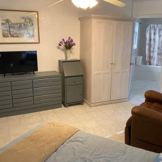 A cozy bedroom with a dresser, wardrobe, and television.