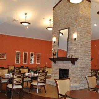 A cozy restaurant dining area with a central fireplace and stylish decor.
