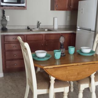 A cozy kitchen with a wooden dining table set for two.