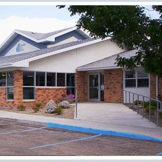 A small brick building with a ramp leading to the entrance.