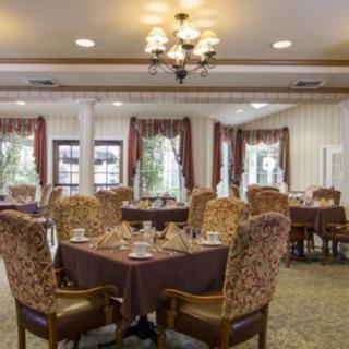 A well-appointed dining room with elegantly set tables and upholstered chairs.