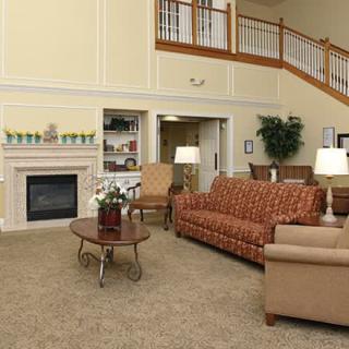 A cozy and well-furnished living room with a fireplace, couches, and a staircase.
