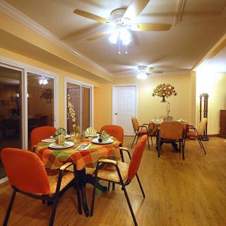 A cozy dining room with elegantly set tables and warm lighting.