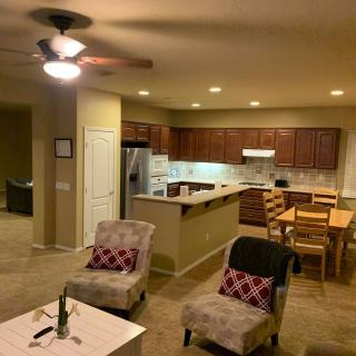 A cozy open floor plan featuring a living room and kitchen with warm lighting and comfortable seating.
