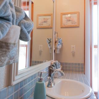 A cozy bathroom with a sink, mirror, and neatly arranged towels.