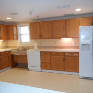 A spacious kitchen with wooden cabinets and modern appliances.
