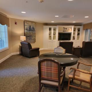 A cozy living room with armchairs, a television, and a small table.