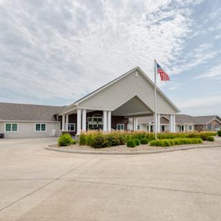 Front view of a building with a flag and parking area.