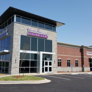 Exterior view of a modern medical clinic with large windows and a parking area.