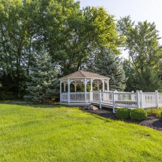 A quaint gazebo surrounded by lush greenery in a tranquil garden.