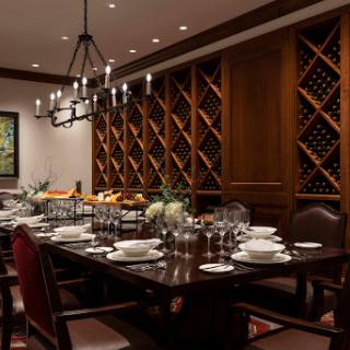 An elegant dining room featuring a beautifully set table and an impressive wine storage area.
