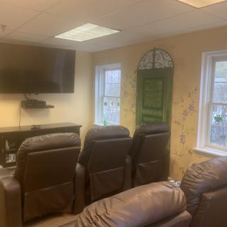 A cozy home theater setup with recliner chairs and a mounted television.