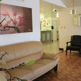 A cozy living room with a beige sofa and floral artwork.