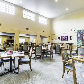A spacious and bright dining room with neatly arranged tables and chairs.