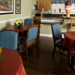 A cozy dining area featuring wooden tables and upholstered chairs, complemented by wall art and decor.