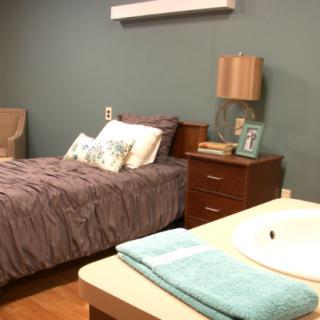 A cozy bedroom with a neatly made bed, nightstand, and simple decor.