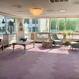 A bright and modern lounge area featuring comfortable seating and large windows, creating a cozy atmosphere.