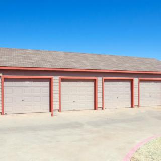 A row of closed garage doors under a clear blue sky.