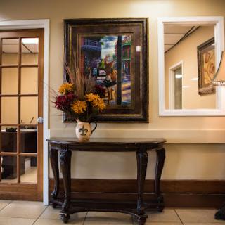 A beautifully decorated entryway featuring a dark wooden table, a floral arrangement, and artwork on the wall.