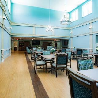 A bright and spacious dining room featuring blue walls and modern furnishings.