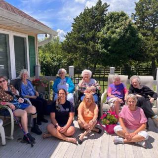 A group of women enjoying a sunny day on a patio.