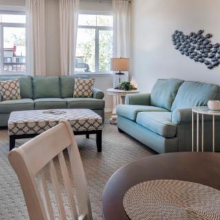 A cozy living room with two sofas, a coffee table, and wall art, creating a comfortable and inviting atmosphere.
