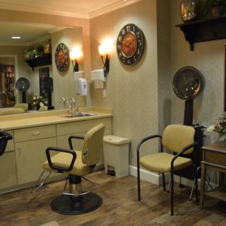 A cozy hair salon interior with chairs, mirrors, and hair drying stations.