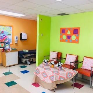 A vibrant and welcoming children's waiting area in a hospital, featuring bright colors and comfortable seating.