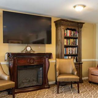 A cozy living room with a fireplace, television, and bookshelves.