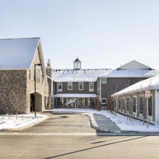 A scenic winter view of a modern building complex with snow-covered roofs and pathways.