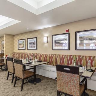 An inviting dining area with tables, chairs, and framed artwork on the walls.