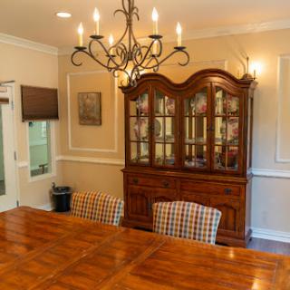 A beautifully arranged dining room featuring a wooden table, checkered chairs, and an elegant chandelier.