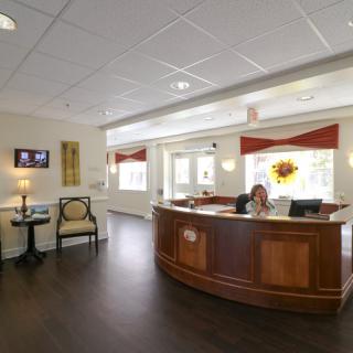 A welcoming reception area with a wooden desk and comfortable seating.