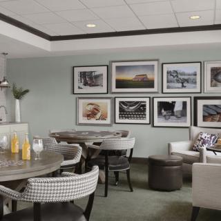A modern lounge area featuring comfortable seating and artwork on the walls.