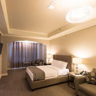 A modern hotel room with a comfortable bed, stylish furniture, and soft lighting.