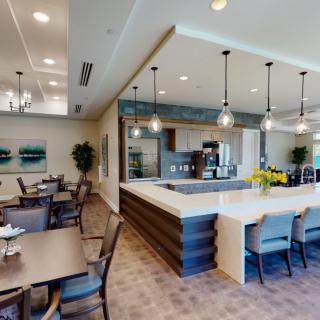 A modern kitchen with an adjacent dining area featuring sleek design and contemporary furnishings.