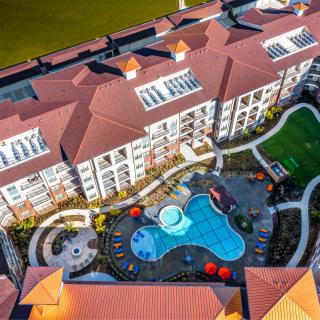 Aerial view of a resort with an outdoor swimming pool and landscaped surroundings.